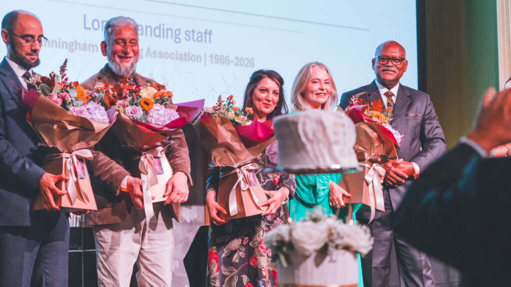 group of staff recieving flowers on stage